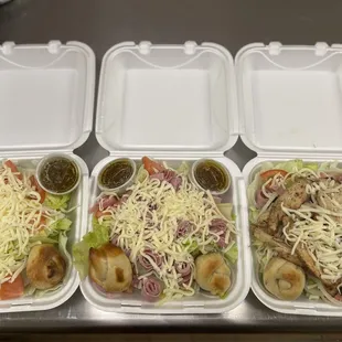 four takeout containers with different toppings