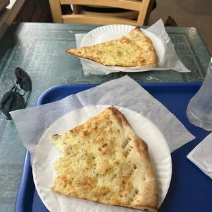 two slices of pizza on paper plates