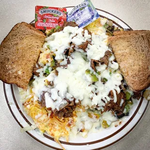 Philly Scramble - hash browns topped with scrambled eggs, philly beef, sautéed green peppers + onions, and covered in melted cheese.