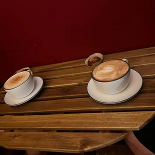 two cups of coffee on a wooden table