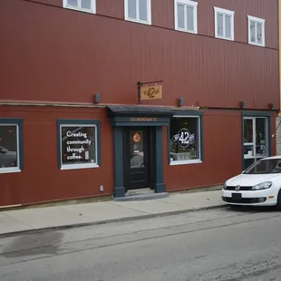 Wide shot of the store front with entrance shown. Hardware store is to the right.
