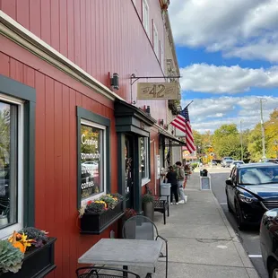 a sidewalk with tables and chairs