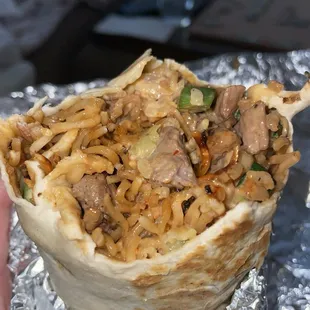 a hand holding a burrito