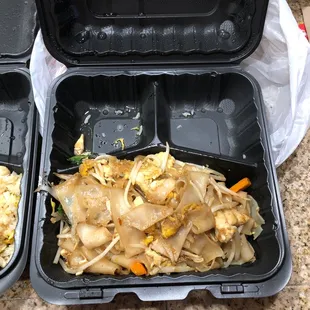 two take out containers with food in them