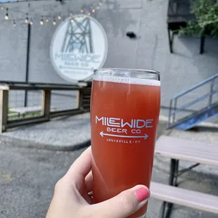 a person holding a glass of beer