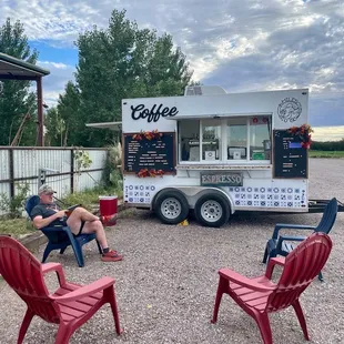 a man sitting in a chair in front of a food truck