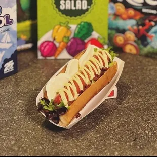 a hot dog in a bun and a box of gum