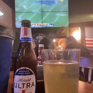 a glass of beer and a bottle of ultra