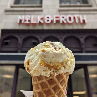 a hand holding a cone of ice cream