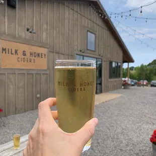 a hand holding a glass of cid