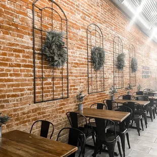 tables and chairs in front of a brick wall