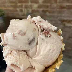 a hand holding a cone of ice cream