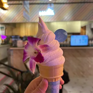 a hand holding a cone of ice cream