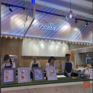 three women standing behind a counter in a restaurant