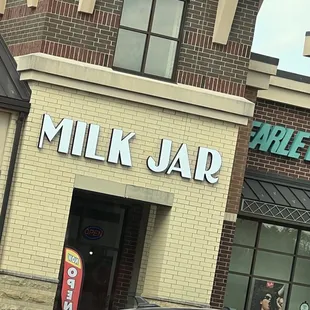 a car parked in front of a milk jar