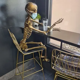 a skeleton sitting at a table