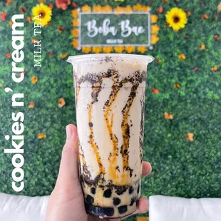  a hand holding a cup of iced coffee