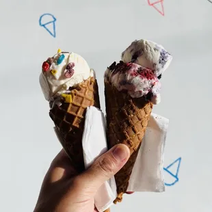 Split scoops of Fruity Pebbles + Rain or Shine (left) and Hello Summer + Red, White and Blue (right) on brown sugar waffle cones