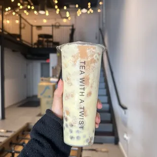 a hand holding a cup of milk tea