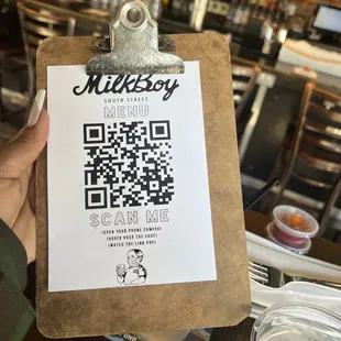 a person holding a clipboard with a qr code on it