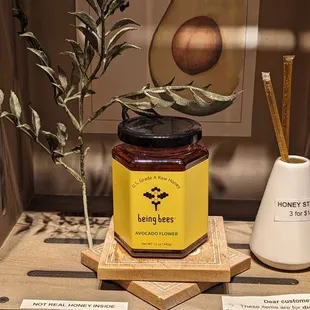 a jar of honey and a plant