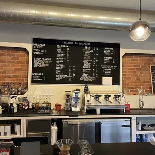 a menu on the wall of a coffee shop