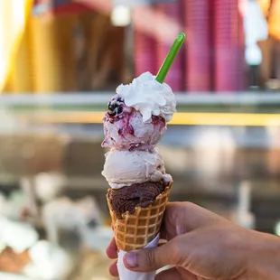 a hand holding a cone of ice cream