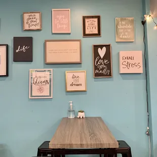 a wooden table and a wall of framed quotes
