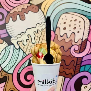 a person holding a cup of ice cream