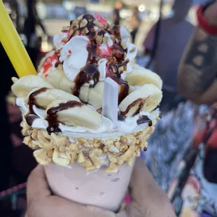 a hand holding a cup of ice cream