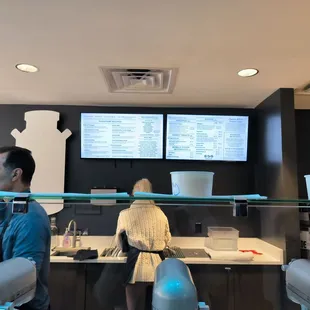 a man and a woman standing in front of the counter