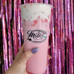 a hand holding a cup of milk