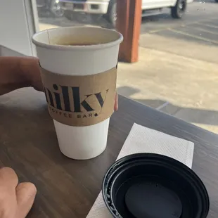 a person sitting at a table with a cup of coffee