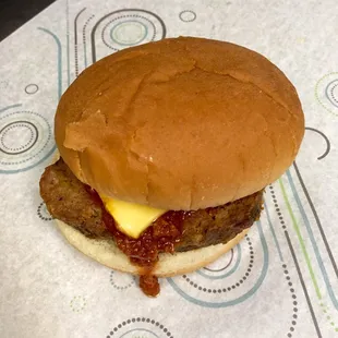 a hamburger with cheese and sauce