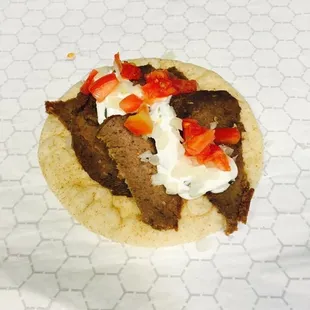 a tortilla with meat, cheese, and strawberries