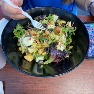 a woman eating a salad with a fork