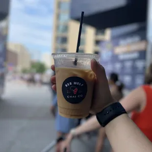 a hand holding a cup of iced coffee