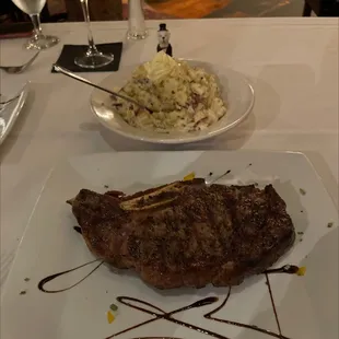 Bone in rib-eye steak and garlic mashed potatoes.
