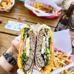 a person holding a sandwich and french fries
