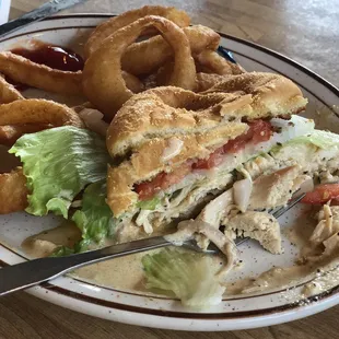 Smoked turkey sandwich with white BBQ sauce and onion rings