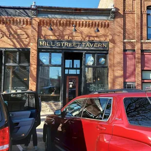 a red car parked in front of the building