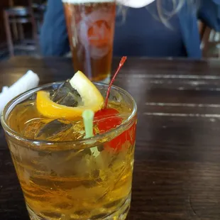 a woman sitting at a table with a drink
