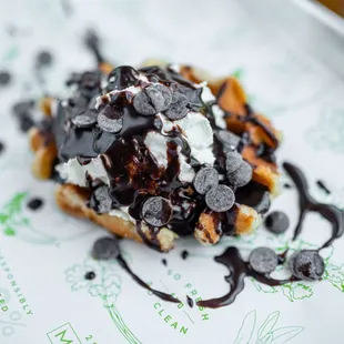 a waffle topped with chocolate and whipped cream