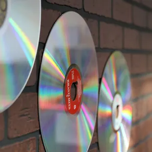 a brick wall with cds on it