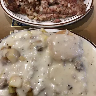 A half portion of biscuits and home fries with sausage gravy and a side of corned beef hash. Huge portions!