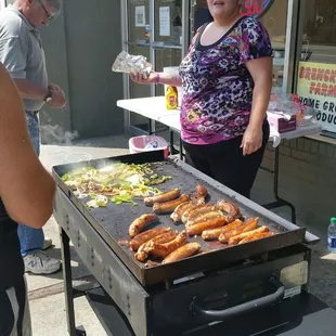 They cook sausage and pepper on a flat grill in front of the store every Friday