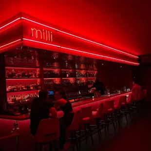 people sitting at a bar with red lighting