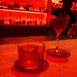 a glass of wine and a drink on a bar counter