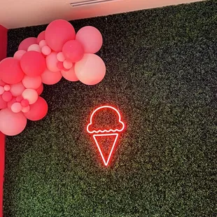 a neon ice cream cone and balloons