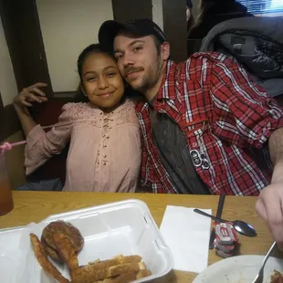 a man and a girl sitting at a table